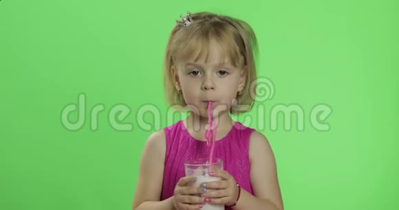 快乐的四岁孩子穿着粉红色的连衣裙喝奶昔鸡尾酒色度键视频的预览图