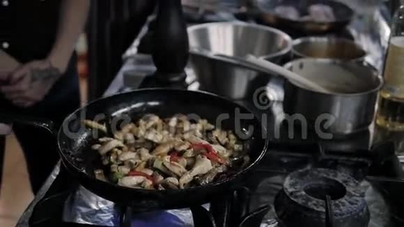 厨师咸菜和油炸蔬菜与肉在煎锅商业厨房烹饪视频的预览图