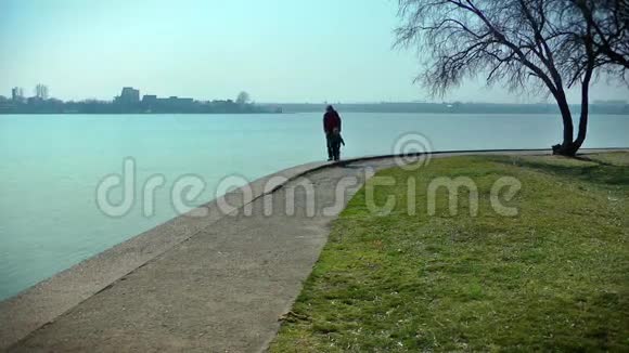 妈妈和小男孩在湖边的公园散步视频的预览图