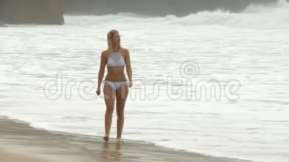 在海洋沙滩上漫步年轻女子暑假视频的预览图