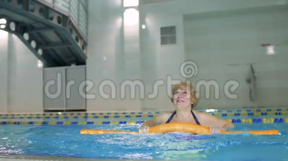 培训人员在游泳池中展示老年妇女健身运动视频的预览图