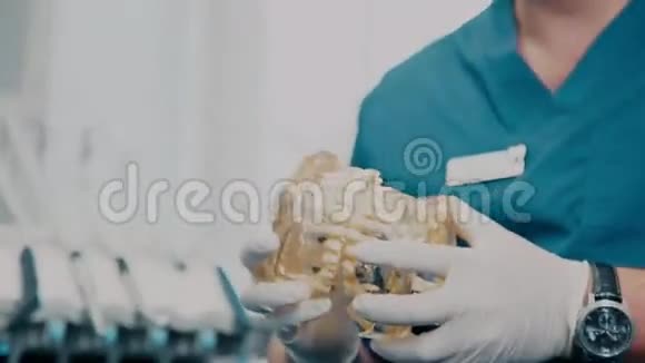 医生用手扭转透明的牙科模型特写视频的预览图