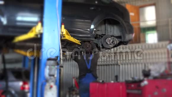 汽车修理工在修理车库修理悬挂的汽车视频的预览图