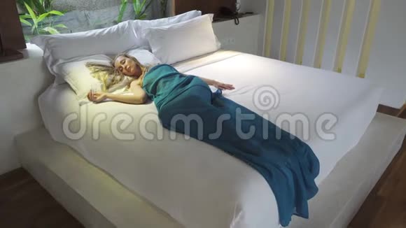 镜头移向卧室围绕着睡在床上的年轻苗条的女人视频的预览图