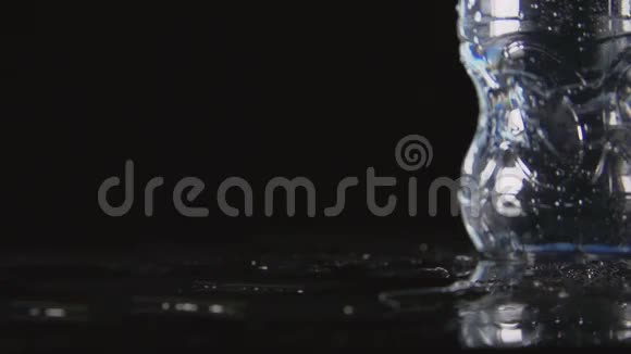 水流落在塑料瓶附近的黑桌上视频的预览图