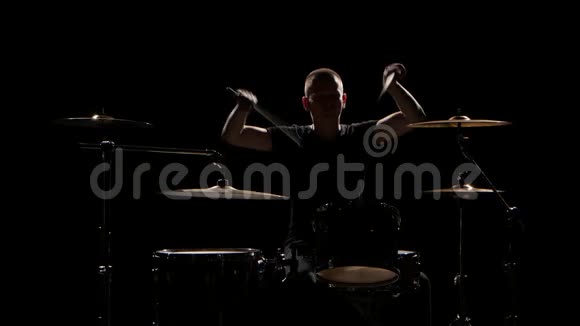 音乐家用棍子在鼓上演奏专业的好音乐黑色背景剪影视频的预览图