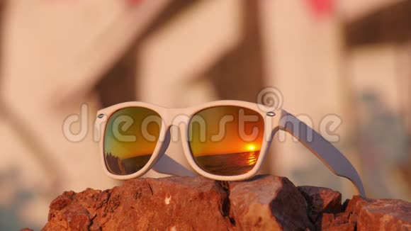 海日落映在石头上的太阳镜上视频的预览图