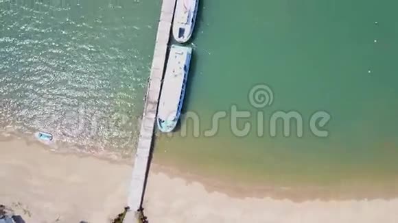 在码头上空在礁石和蓝色海洋上空飞行美丽海滩的空中景色视频的预览图