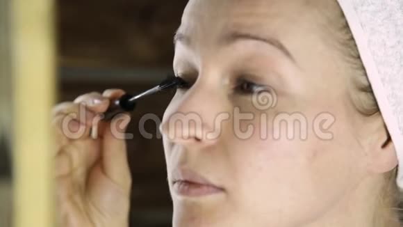 一位身穿毛巾的美女在镜子前画睫毛视频的预览图