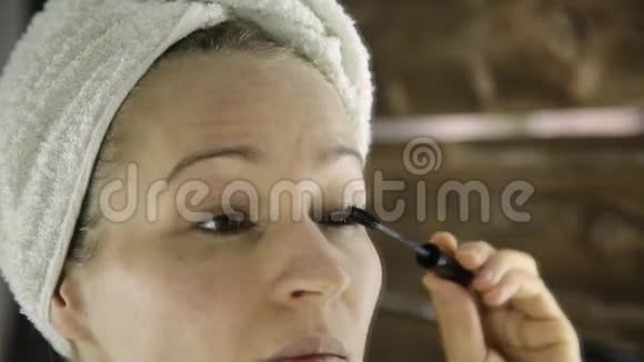 一位身穿毛巾的美女在镜子前画睫毛视频的预览图