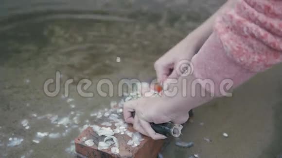河边的女人用刀子清理鱼户外关门视频的预览图