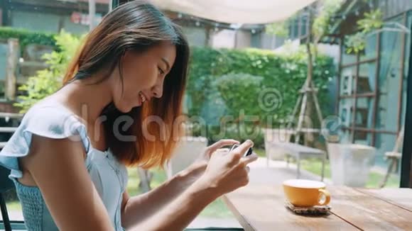 一位年轻女士在智能手机上拍摄咖啡茶用手机相机拍摄餐品视频的预览图