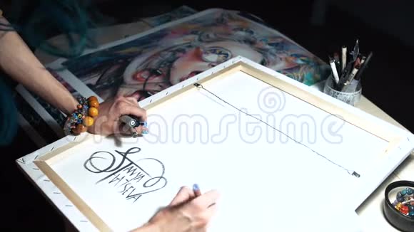女艺术家在他的一些作品上签名一个大师的彩绘标志担架上的帆布签名黑色记号笔视频的预览图