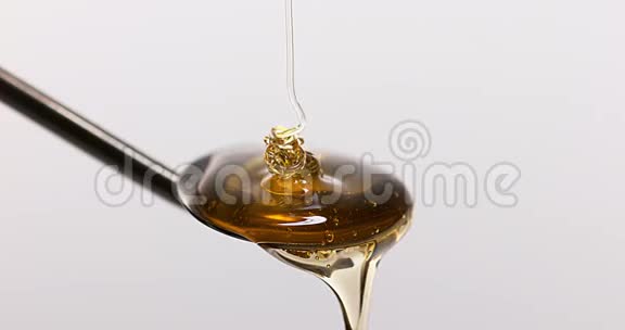 在白色背景下在勺子上流动蜂蜜视频的预览图