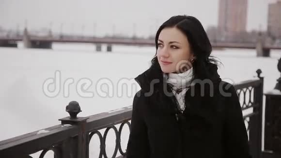 在冰冻的冬季河桥上行走的女人视频的预览图