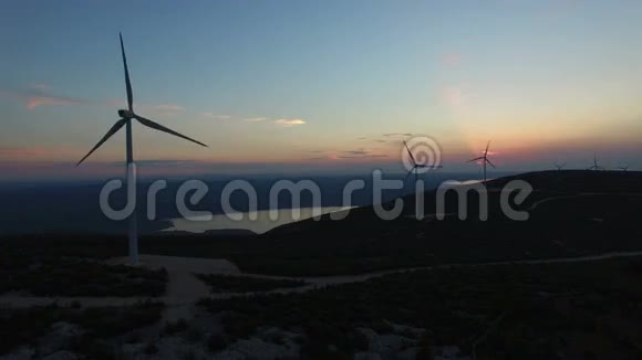 日落时分在白色风力涡轮机上面飞行视频的预览图