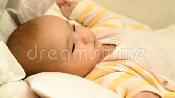 小可爱的新生婴儿躺在婴儿床上视频的预览图