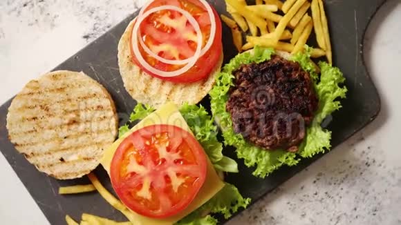 两个美味的烤家庭汉堡配牛肉番茄洋葱和生菜视频的预览图