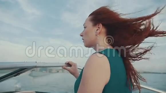在摩托艇上穿裙子的红头发女孩美丽的夏风黄昏自由视频的预览图