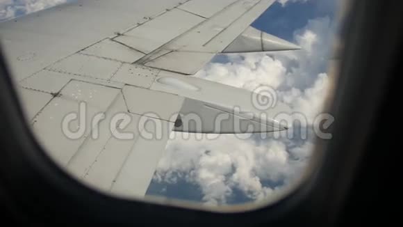 飞行中飞机机翼下的地面和云层视频的预览图