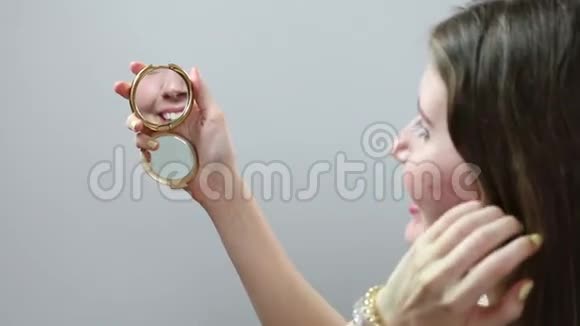 年轻女孩在白色背景下照镜子视频的预览图