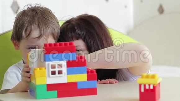 快乐的孩子和妈妈玩彩色积木视频的预览图