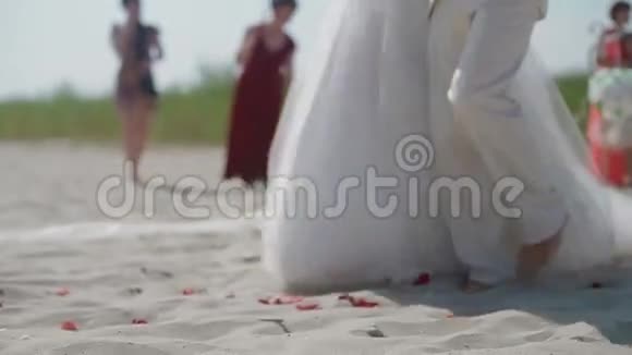 一对新婚夫妇在海滩上走到祭坛前视频的预览图