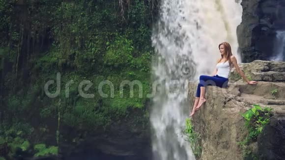 坐在特根甘瀑布旁边悬崖上的女人视频的预览图