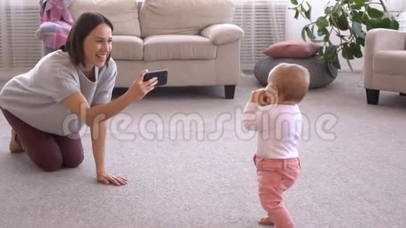 妈妈用手机拍照给女婴拍照视频的预览图
