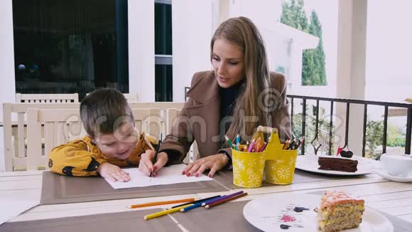 妈妈和小男孩在桌子上用蜡笔画画视频的预览图