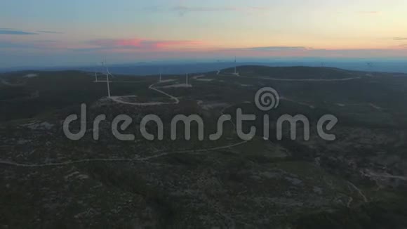 日落时提供十几台风力发电机组的空中景观视频的预览图