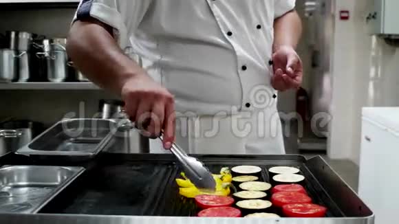 厨师长用专业烤制蔬菜用火钳烧烤食材辣椒番茄视频的预览图