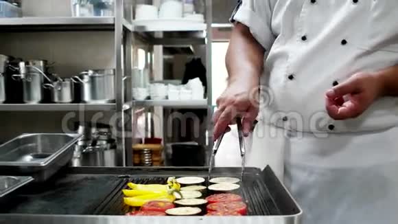 厨师长在餐馆里用专业烧烤的方法准备蔬菜辣椒西红柿茄子等视频的预览图