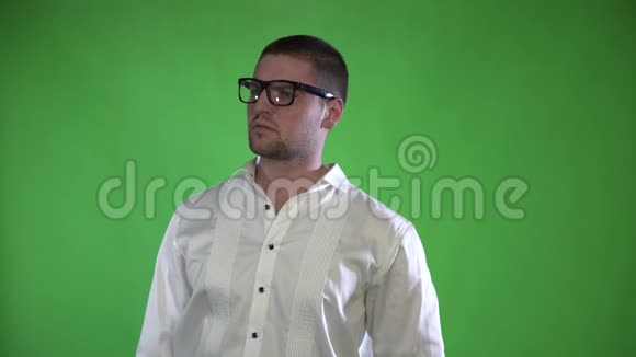 一个戴着刚毛和眼镜的变形人用绿色背景上的全息图控制着他的手视频的预览图