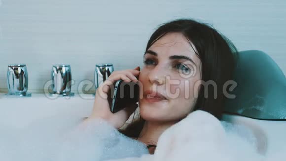 布鲁内特女孩享受充满泡沫的浴室在电话里聊天别紧张休息视频的预览图