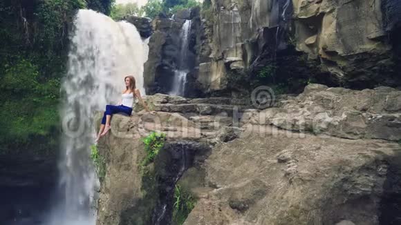 坐在特根甘瀑布旁边悬崖上的女人视频的预览图