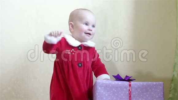 一个小孩站在一个盒子旁边带礼物视频的预览图