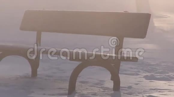 雪地和晨雾上的木制长凳视频的预览图
