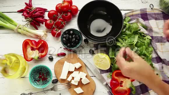 女人撕下菠菜把它放在碗里准备沙拉视频的预览图