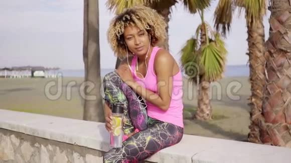 美丽的女人在海滩上锻炼休息视频的预览图