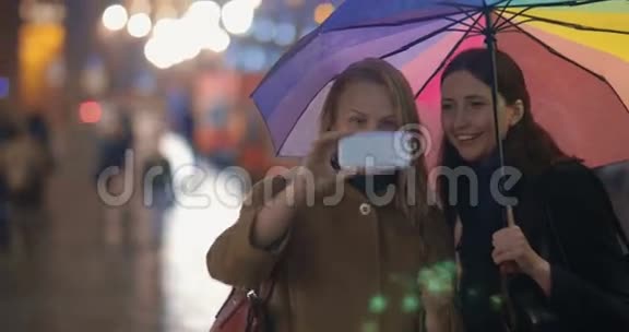 晚上下雨的城市女人在拍滑稽的自拍视频的预览图