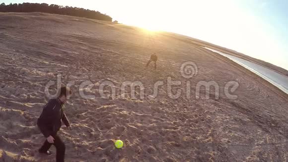 足球在海滩上夕阳西下人们正在运动踢球踢足球剪影生活方式视频的预览图