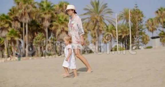 妈妈和她的小女儿在沙滩上散步视频的预览图