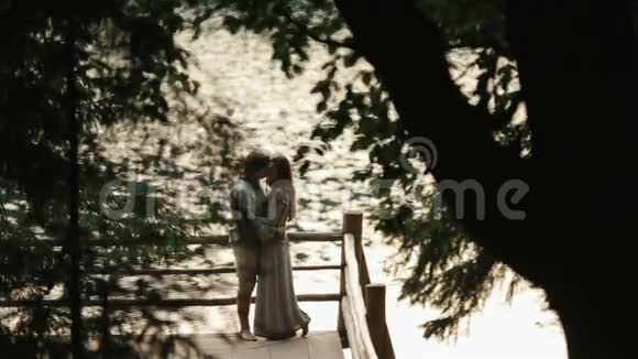 一对幸福的年轻夫妇站在湖边的山上轻轻地拥抱着喀尔巴阡山脉乌克兰视频的预览图