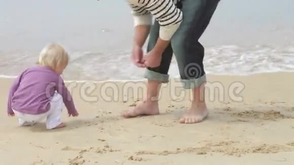 父亲和女儿在海岸线上收集贝壳视频的预览图