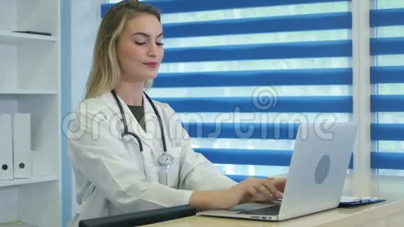 微笑的护士在笔记本电脑上打字在前台做笔记视频的预览图