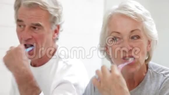 高级夫妇反映在浴室镜子刷牙视频的预览图