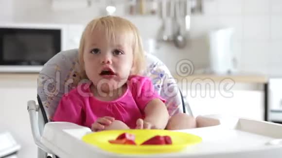 坐在高椅上吃草莓的女孩的时间流逝视频的预览图