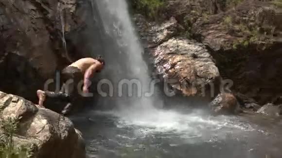 盖伊在热带公园瀑布处跳入河池视频的预览图