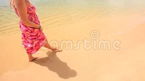 穿着红长衣的女孩赤着脚在沙滩水上漫步视频的预览图